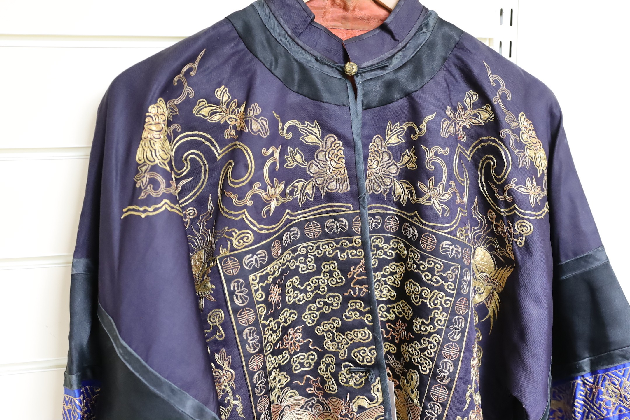 A 20th century Chinese robe, decorated with navy ground and gilt thread all over five claw dragons